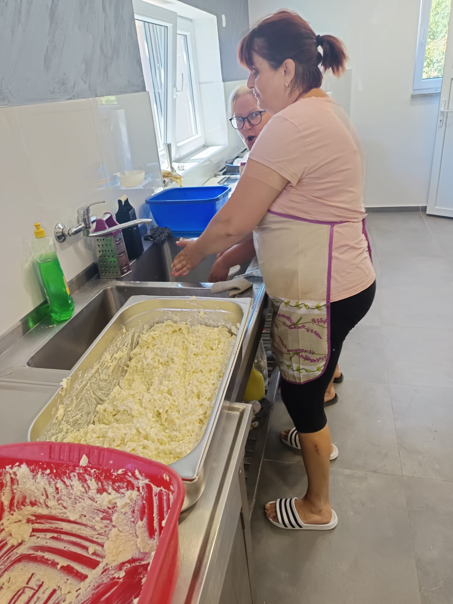 Žene u kuhinji vatrogasnog doma pripremaju nadjev od domaćeg svježeg sira za štruklje