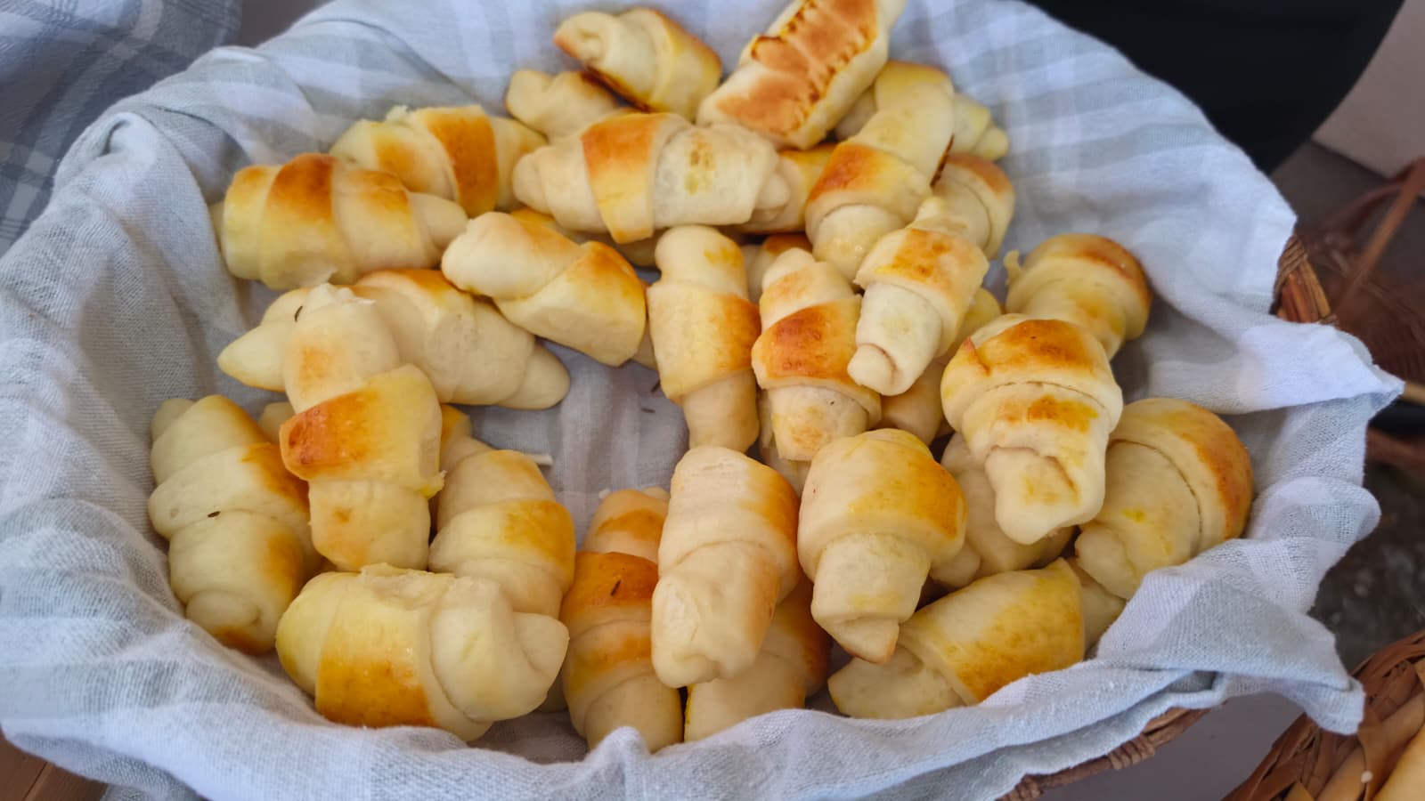 Stol prepun domaćih peciva na 18. Slivarijadi — košare kifli, slanih štapića, orehnjača i pita sa sirom