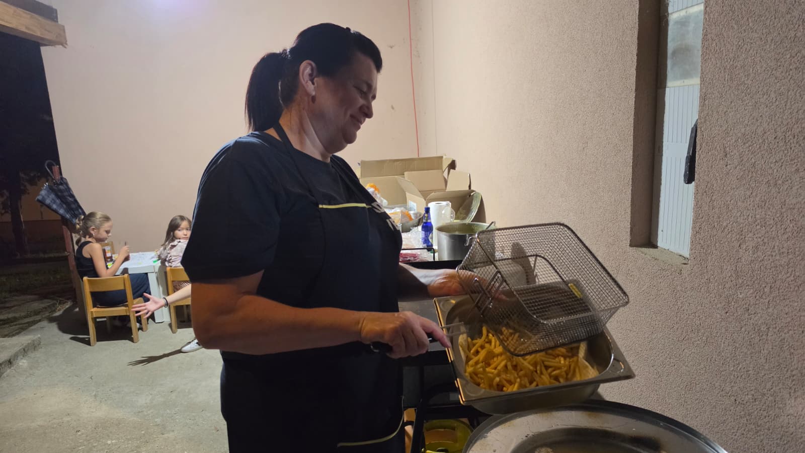 Članica DVD-a Dropkovec priprema pommes u velikoj fritezi tijekom večeri