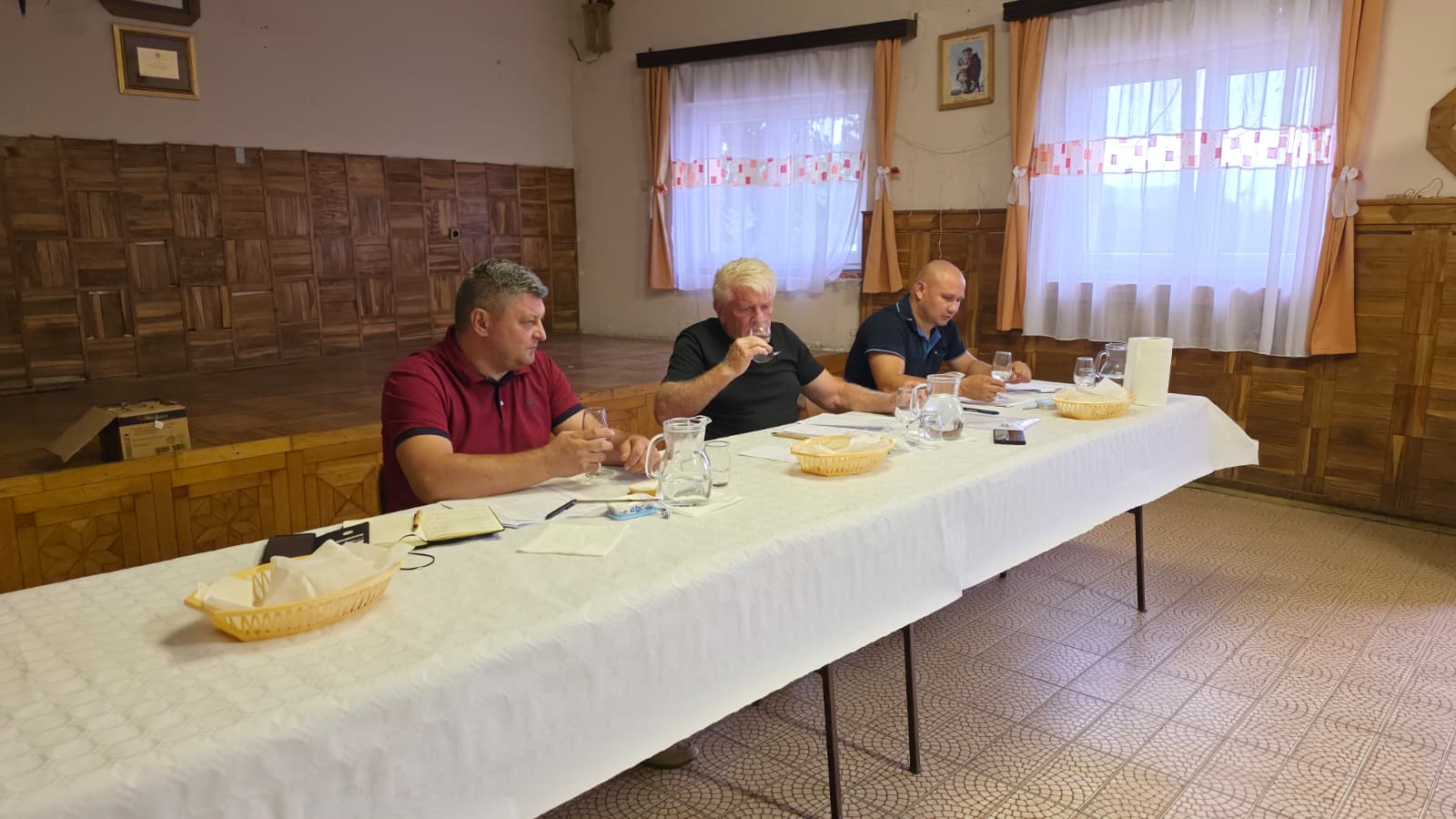 Ocjenjivači kušaju i ocjenjuju uzorak rakije za stolom u dvorani vatrogasnog doma