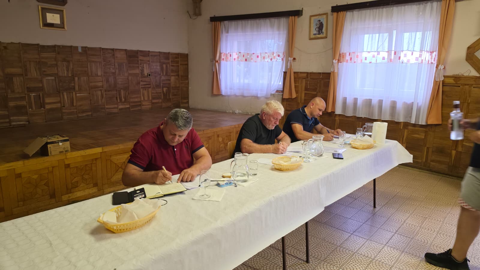 Tri člana stručnog povjerenstva upisuju bodove u ocjenjivačke listove tijekom ocjenjivanja rakija