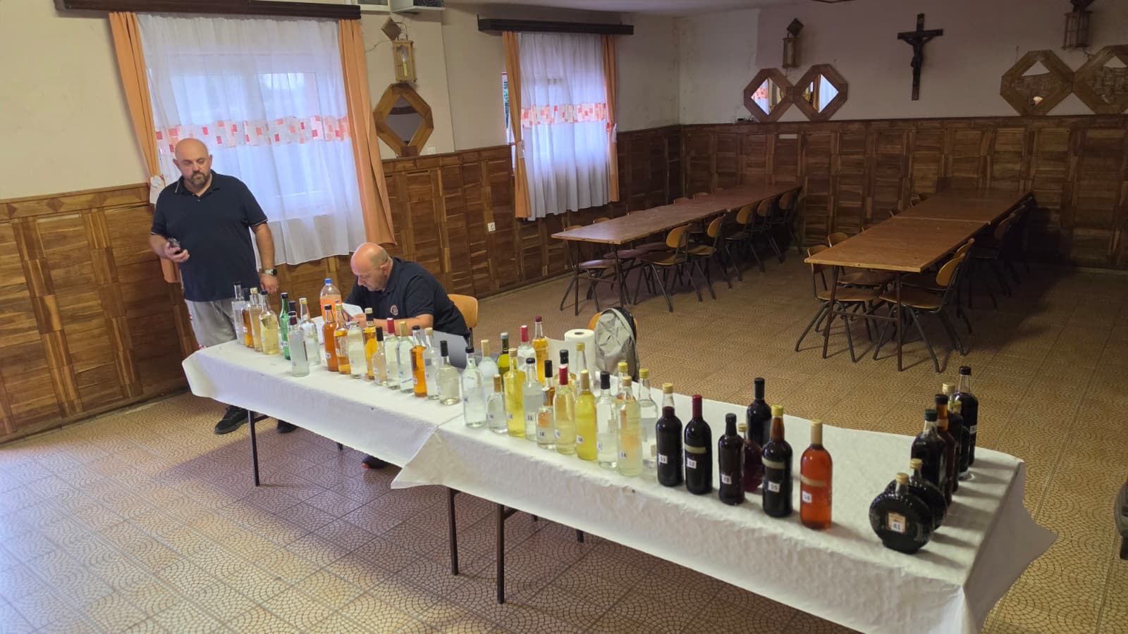 Pogled na stol s 51 uzorkom šljivovica, voćnih rakija i likera u dvorani vatrogasnog doma prije ocjenjivanja