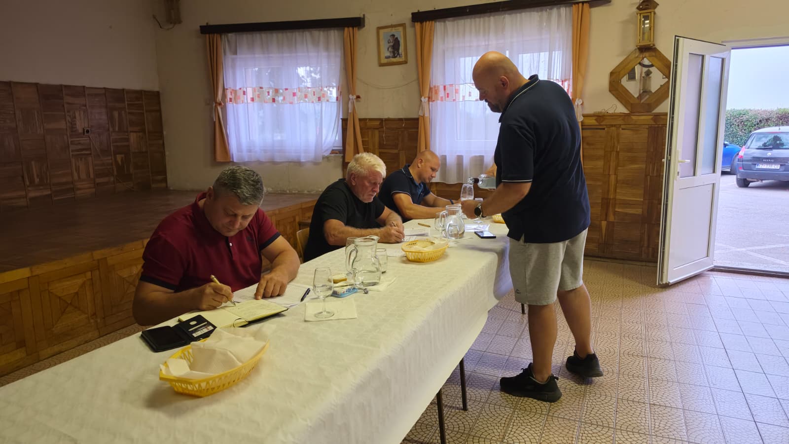 Ocjenjivači zapisuju bodove u ocjenjivačke listove dok član DVD-a Dropkovec priprema sljedeći uzorak