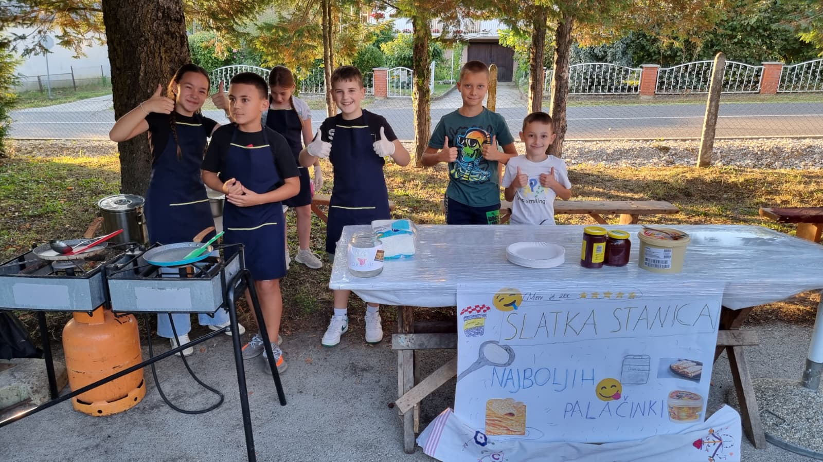 Djeca u pregačama ponosno poziraju uz svoj štand Slatka stanica najboljih palačinki